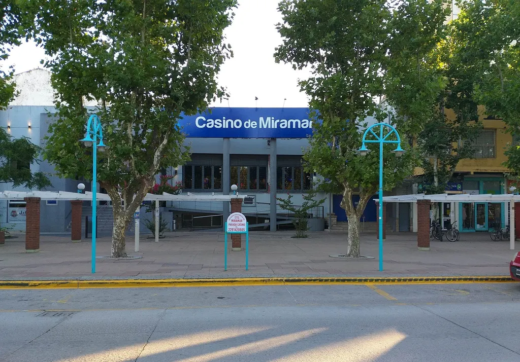 The Casino de Miramar sign above its entrance, seen across the tree-lined street — Casino de Miramar