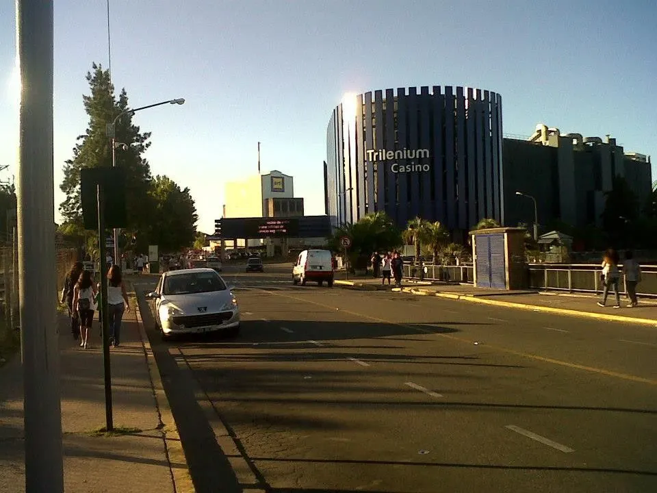The round glass tower of Trilenium Casino, with its sign, seen from the street in Tigre — Casino de Tigre - Trilenium